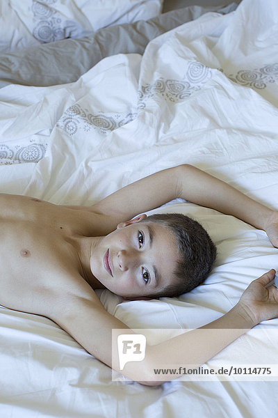 Boy reclining on bed  portrait