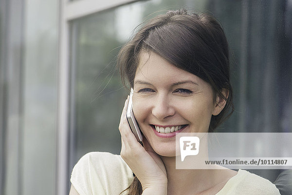Frau benutzt Handy  lächelt fröhlich