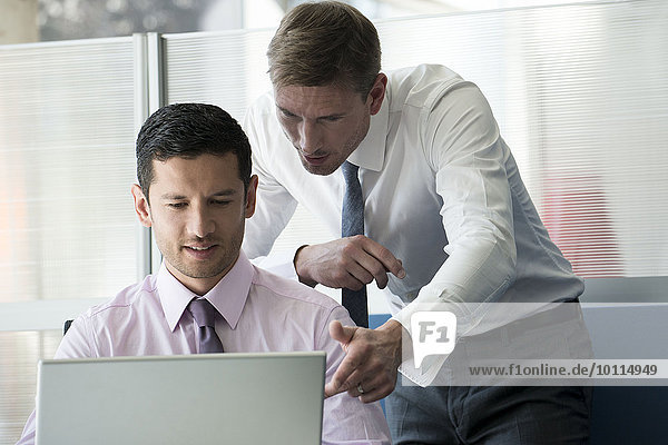 Businessman and colleague looking at computer together
