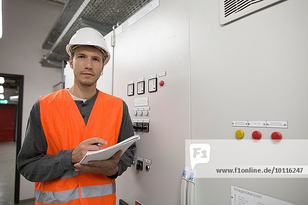 Portrait of young male engineer in technical room