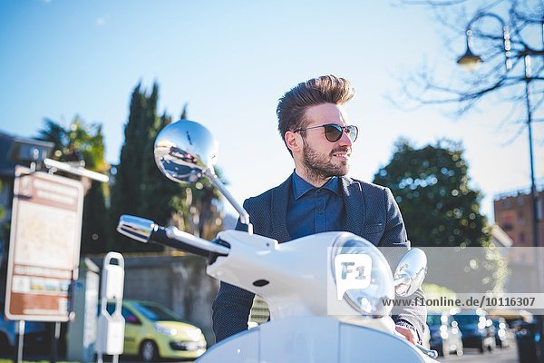 Stilvoller junger Mann auf Moped