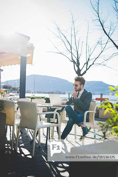 Geschäftsmann mit Laptop im Café am See  Rovato  Brescia  Italien