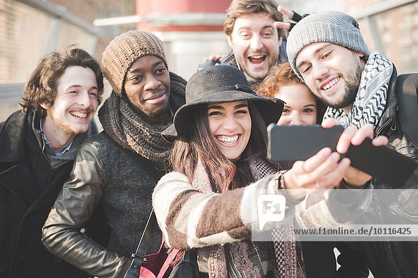Sechs junge erwachsene Freunde  die Selfie auf dem Smartphone nehmen