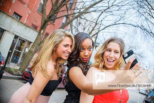 Drei junge erwachsene Freundinnen nehmen Smartphone Selfie auf die Straße