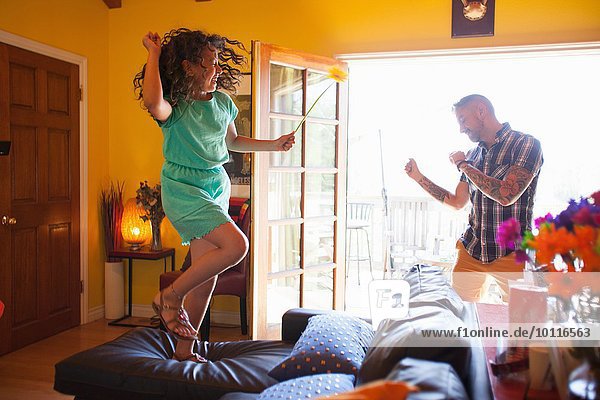 Mädchen und Vater tanzen im Wohnzimmer