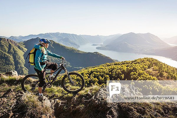 Junge Frau auf dem Mountainbike  Blick auf den Comer See  Italien