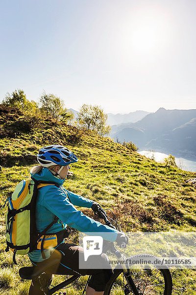 Young woman on mountain bike  looking at view  Lake Como  Italy