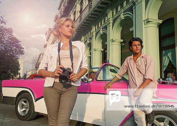 Junges Paar mit Vintage Cabriolet beim Fotografieren  Havanna  Kuba