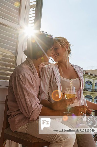 Romantisches junges Paar trinkt Wein auf dem Balkon des Restaurants in Plaza Vieja  Havanna  Kuba