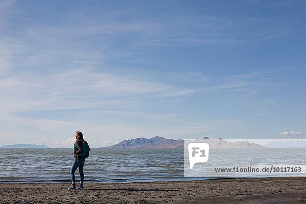 Rückansicht einer jungen Frau  die am Rande des Wassers steht  Great Salt Lake  Utah  USA