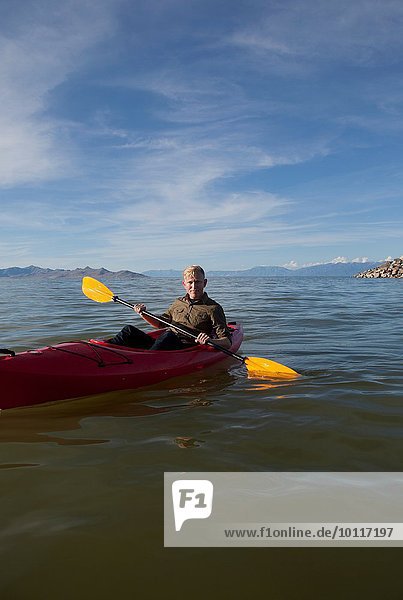 Junger Mann im Kajak mit Paddeln  Blick auf die Kamera  Great Salt Lake  Utah  USA