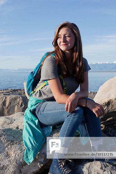 Junge Frau auf Felsen sitzend  auf Ellbogen gestützt  wegschauend  Great Salt Lake  Utah  USA