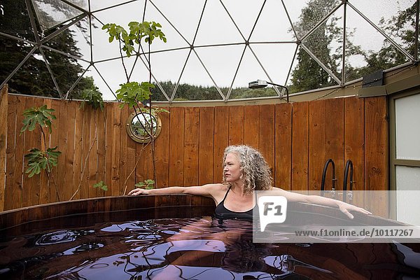 Reife Frau entspannt im Whirlpool beim Öko-Retreat