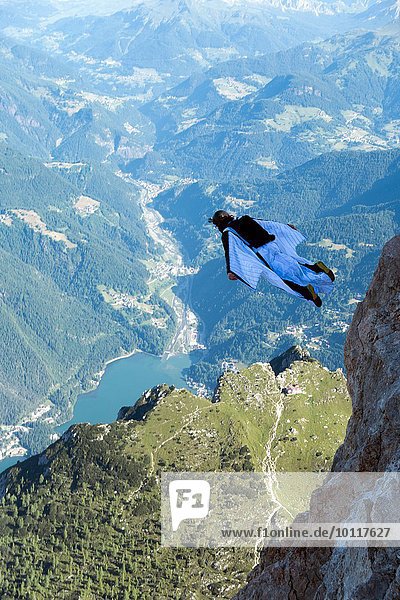 Männlicher BASE Jumper Wingsuit über dem Tal  Dolomiten  Italien