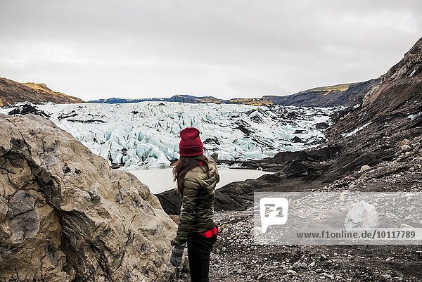 Female tourist pointing at glacier at Solheimajokull  Iceland