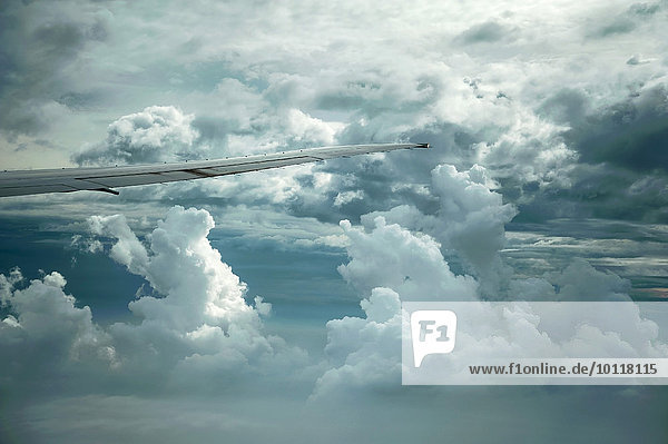 Dramatische Wolkenbildung und Tragfläche Boing 777-300