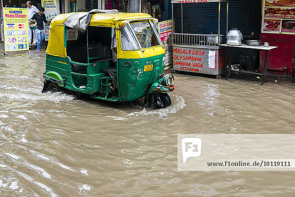 Eine Motor-Rikscha fährt durch die nach einem heftigen Monsunregenfall überfluteten Straßen der Vorstadt Paharganj  Neu-Delhi  Delhi  Indien  Asien