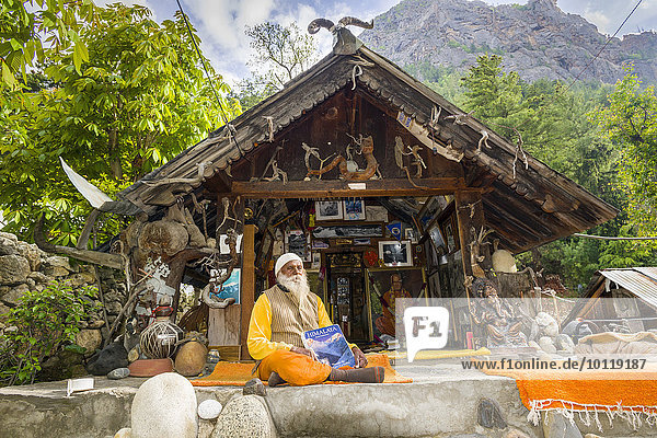 Swami Sundaranand, ein berühmter Sadhu, Yogi und Fotograf, sitzt vor seinem Haus mit seinem Buch, Gangotri, Uttarakhand, Indien, Asien