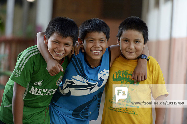 Three boys  friends embracing each other  Puerto Maldonado  Madre de Dios department  Peru  South America