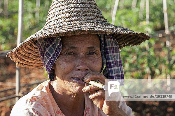 Einheimische Frau mit typischer Kopfbedeckung raucht eine Zigarre  Portrait  Indein  Inle-See  Shan-Staat  Myanmar  Asien