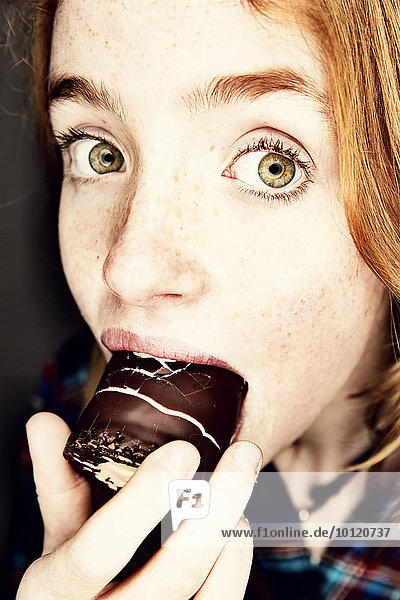 Girl eating a chocolate-coated marshmallow   Germany  Europe