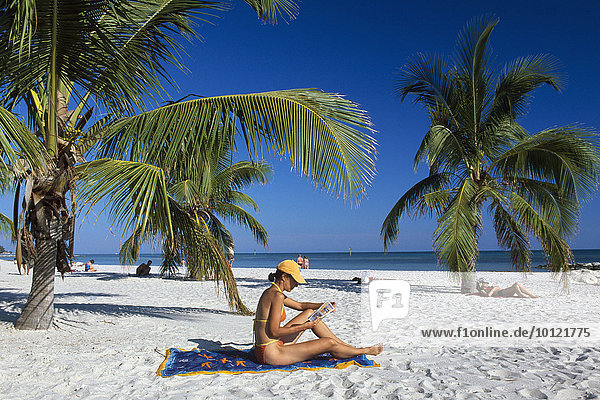 Frau liest  Sandstrand  Palmen  Smathers Beach  Key West  The Keys  Florida  USA  Nordamerika