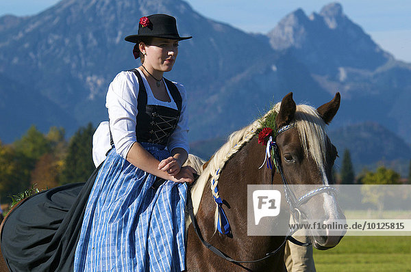 Frau in Tracht auf Pferd  Wallfahrt nach Sankt Koloman bei Füssen  Allgäu  Bayern  Deutschland  Europa