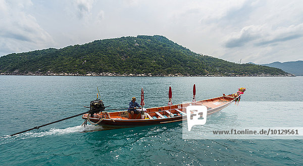 Thailändischer Mann lenkt ein Longtail-Boot  Insel Koh Tao  Golf von Thailand  Thailand  Asien