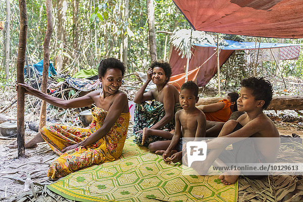 Frauen und Kinder der Orang Asil sitzen unter Planen im Dschungel  Ureinwohner  indigenes Volk  tropischer Regenwald  Nationalpark Taman Negara  Malaysia  Asien
