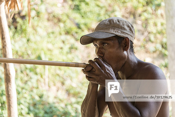 Orang Asli native man shooting a blowgun  Taman Negara  Malaysia  Asia