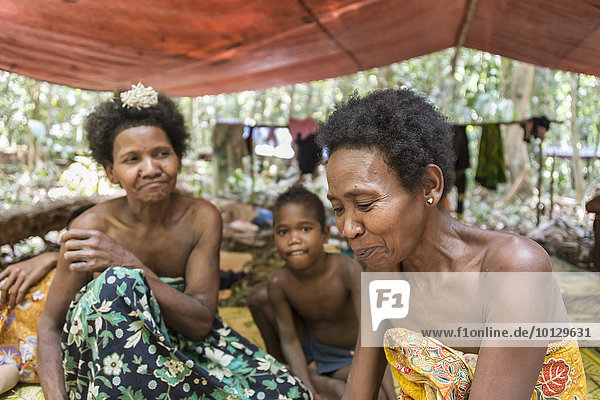 Frauen und Kinder der Orang Asil sitzen unter Planen im Dschungel  Ureinwohner  indigenes Volk  tropischer Regenwald  Nationalpark Taman Negara  Malaysia  Asien