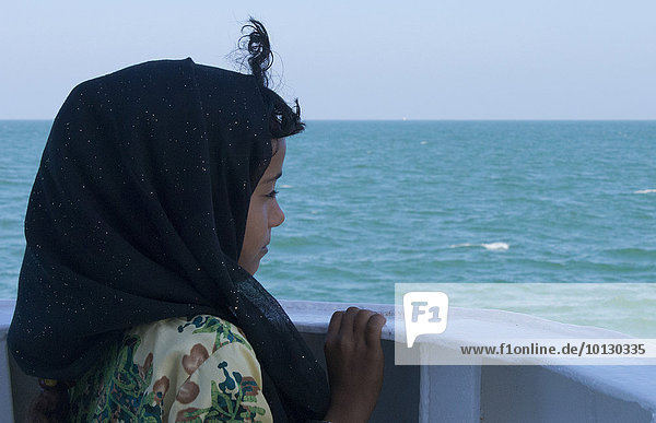 Omani girl gazing at the ocean  Oman  Asia