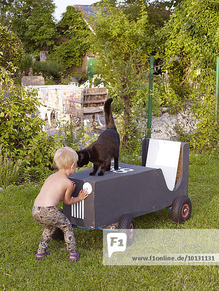 Girl playing in garden with cat