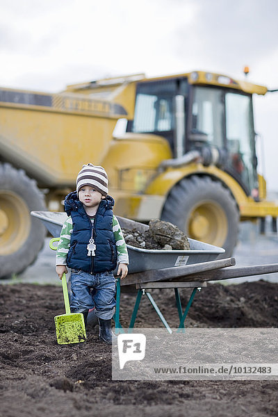 Boy with shovel  digger on background