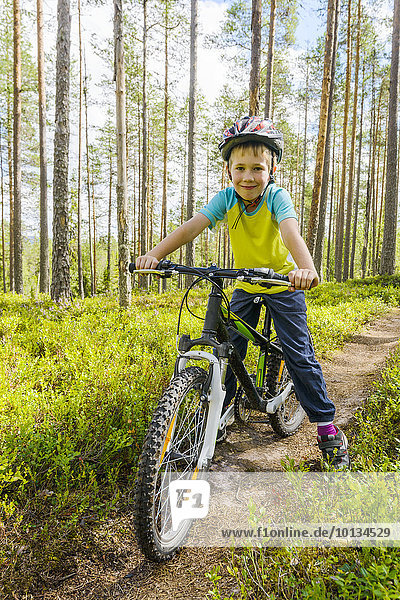 Boy cycling through forest