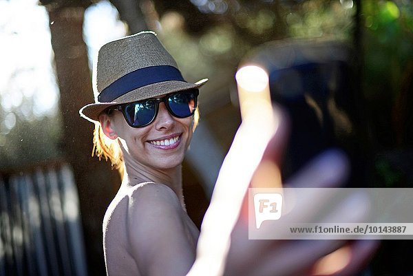 Attractive young woman taking a selfie on the beach Ibiza Balearic Islands Spain.