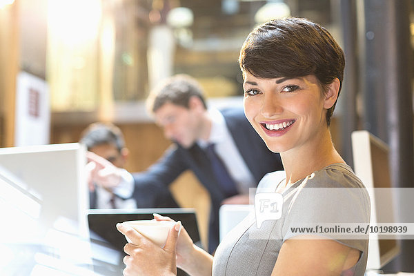 Portrait selbstbewusste Geschäftsfrau beim Kaffeetrinken im Büro