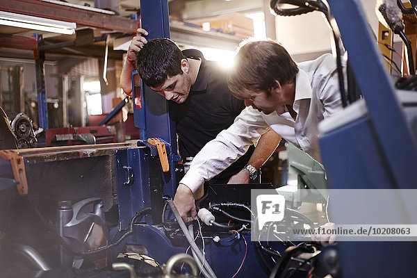 Mechanics working on car in auto repair shop