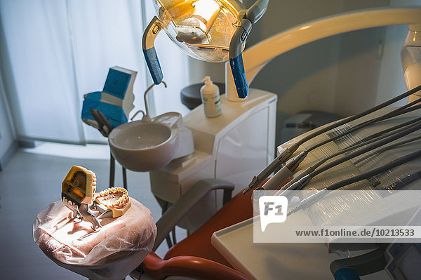 Empty chair and dentures in office of dentist