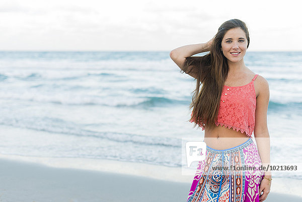 Hispanic woman standing on beach