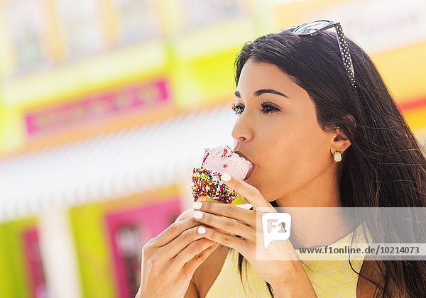 kegelförmig Kegel Außenaufnahme Frau Hispanier Eis essen essend isst Sahne freie Natur