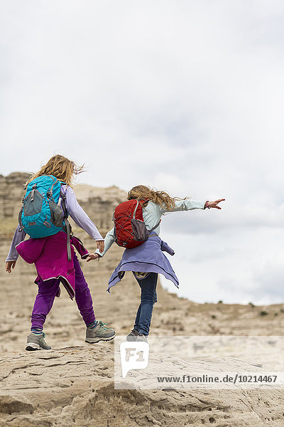 Caucasian girls exploring desert rock formations