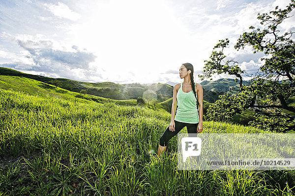 Mixed race athlete standing on rural hillside