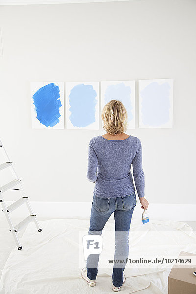 Caucasian woman examining paint samples in new home