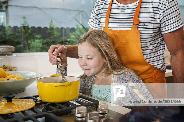 Caucasian father and daughter cooking in kitchen