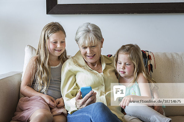 Handy benutzen Europäer Couch Enkeltochter Großmutter