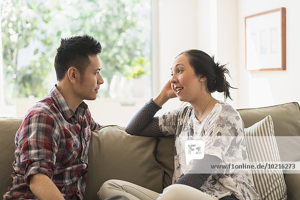 Couple talking on sofa in living room