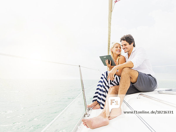 Couple using digital tablet boat deck