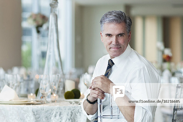 Caucasian businessman smiling in empty dining room