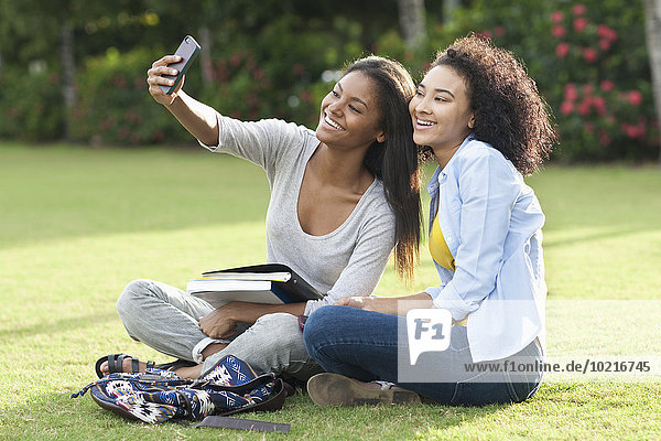 Black women taking selfie in park